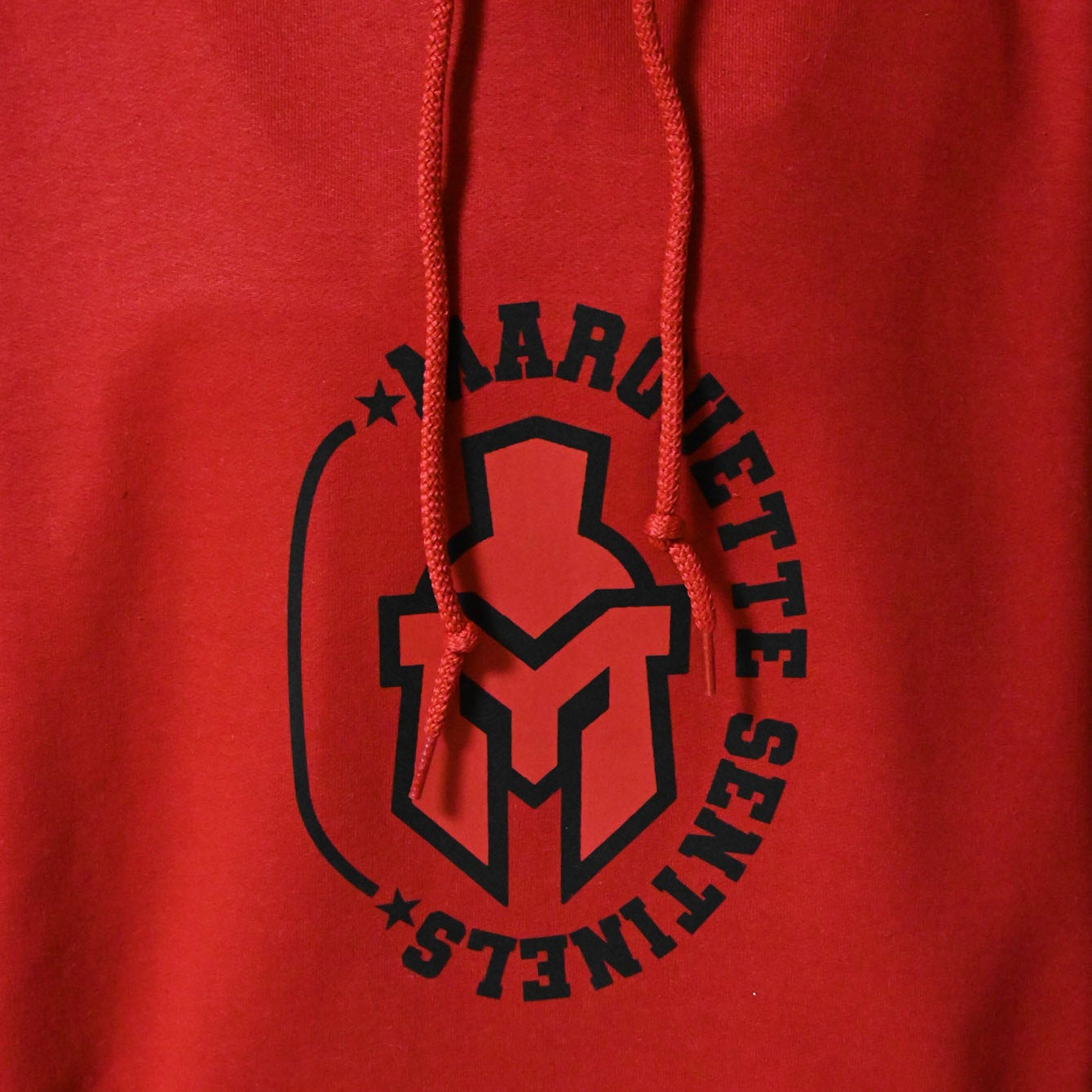Sentinel Helmet with "Marquette Sentinels & Stars border on Red Hoodie